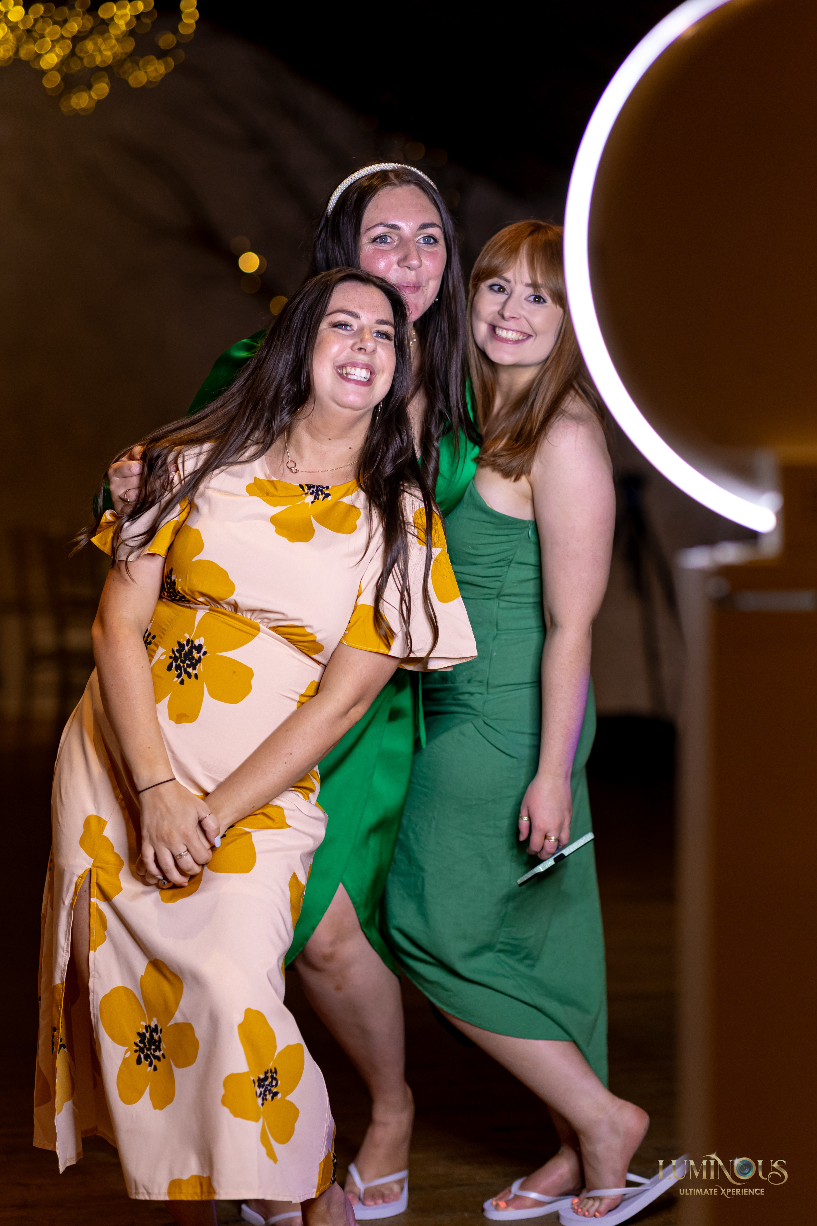 A group of wedding guests having fun posing for photos on thhe Mobi Aura booth